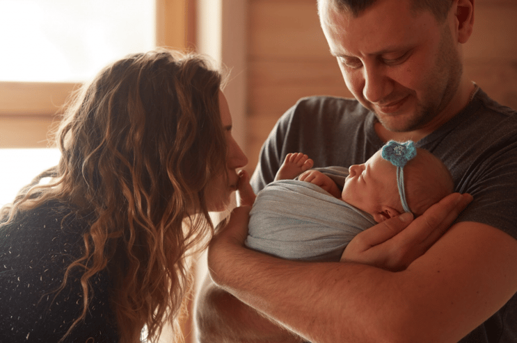 mother kissing newborn baby
